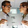 Portrait of young microbiologists holding an x-ray film with a dna pattern