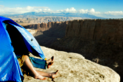Couple sleeping in tent by cliff, high angle view, Moab, Utah, USA