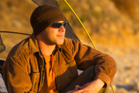 A man sits in the door of his tent at sunset in Palos Verdes, California