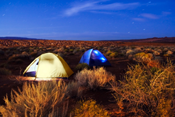 A pair of tents glow in the twilight in the campground at Sand Hollow State Park, Utah