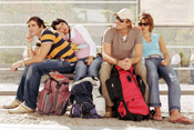 Two couples sitting at bus stop with rucksacks, Granada, Spain