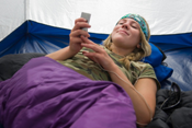young woman listening to MP3 player in tent