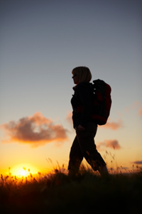 Female walker with setting sun